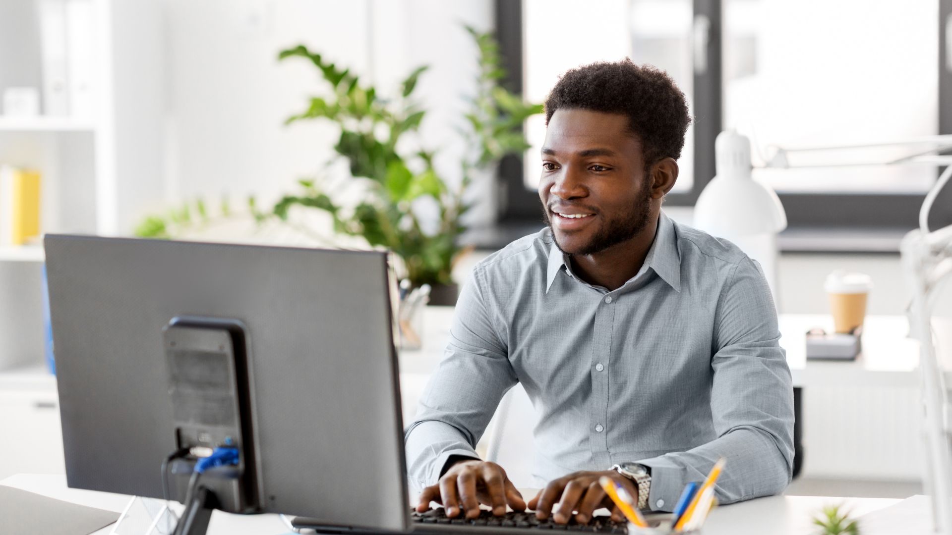 A man at his computer looking into why automated CAD software is superior to manual. 